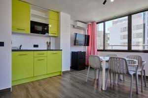 a kitchen with yellow cabinets and a table with chairs at Now Benidorm in Benidorm