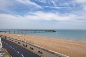a road next to a beach with a pier at The Coastal Hideaway in Deal