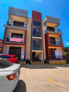 a building with a car parked in front of it at Spacious 1Bedroom Apartment in Muyenga off Bukasa Road in Kampala