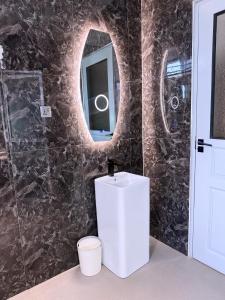 a bathroom with a sink and a mirror at Spacious 1Bedroom Apartment in Muyenga off Bukasa Road in Kampala +38 photos