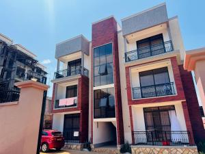 aartment building with a red car parked in front of it at Spacious 1Bedroom Apartment in Muyenga off Bukasa Road in Kampala