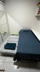 a bed with blue sheets and pillows in a room at Apt FIG 2025 in Garanhuns +7 photos