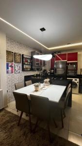 a kitchen with a large white table and chairs at Apt FIG 2025 in Garanhuns