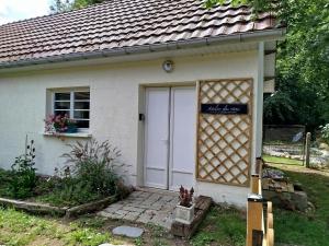 a white garage with a sign on the door at Chambre vallée de la course in Parenty