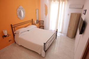 a bedroom with a bed and a television in it at Dream on the blue house 2 in Valderice +4 photos