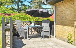 a table and two chairs with an umbrella at Awesome Home In Nørre Nebel With Wifi in Nørre Nebel +9 photos
