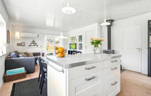 a kitchen with white cabinets and a living room at Awesome Home In Nørre Nebel With Wifi in Nørre Nebel