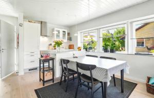a kitchen with a table and chairs and windows at Awesome Home In Nørre Nebel With Wifi in Nørre Nebel