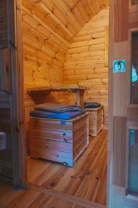 a wooden cabin with two beds in a room at Happis Fassle in Tarrenz