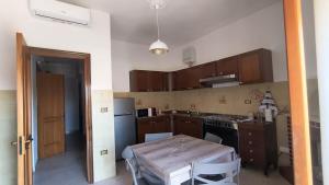 a kitchen with a table and a small kitchen with brown cabinets at L'Imperiale Granaio Casa Vacanze in Rocca Imperiale