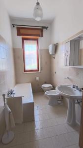 a bathroom with a tub and a toilet and a sink at L'Imperiale Granaio Casa Vacanze in Rocca Imperiale