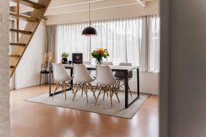 a dining room with a table and chairs at - Het Kleine Nest - nabij het meer, strand & Keukenhof in Noordwijkerhout