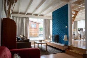 a living room with a red couch and a blue wall at - Het Kleine Nest - nabij het meer, strand & Keukenhof in Noordwijkerhout