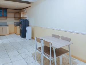 a kitchen with a table and chairs and a refrigerator at RedDoorz at Yssa Ademar near Robinsons Jaro in Iloilo City +13 photos