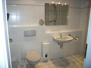a bathroom with a toilet and a sink at Strandläufer im Haus Strelasund in Binz