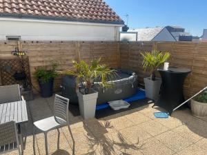 a patio with a tub with plants in it at Maison a étages bord de mer in Notre-Dame-de-Monts