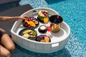 a tray filled with food and drinks in a pool at Villa Seawadee - luxurious, award-winning design Villa with amazing panoramic seaview in Chaweng Noi Beach