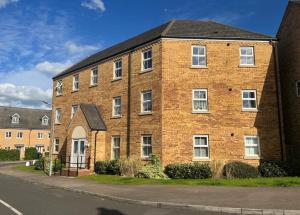 a large brick building on the side of a street at 2 bed apartment Moulton Park in Spinney Hill