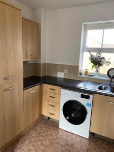 a kitchen with a washing machine in a kitchen at 2 bed apartment Moulton Park in Spinney Hill