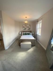 a bedroom with a large bed and a chandelier at 2 bed apartment Moulton Park in Spinney Hill