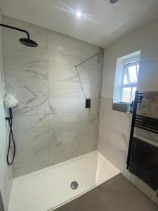 a bathroom with a shower with white marble tiles at 2 bed apartment Moulton Park in Spinney Hill +3 photos