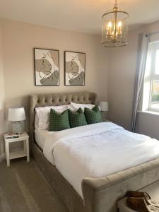 a bedroom with a large bed with green pillows at 2 bed apartment Moulton Park in Spinney Hill