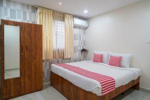 a bedroom with a large bed with red and white pillows at Open Hotel by Olive - The Emerald Inn in Bengaluru