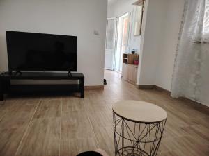 a living room with a flat screen tv and a table at Prominska Bajka in Razvođe