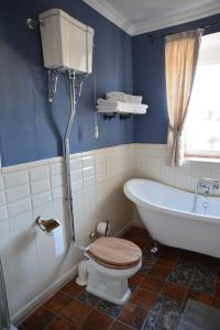 a bathroom with a tub and a toilet and a sink at Gästehaus auf der Burg im Vulkan Park Laacher See in Andernach