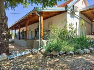 a house with a porch with a wooden roof at Prominska Bajka in Razvođe