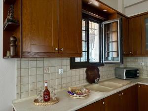 a kitchen counter with a sink and a microwave at Stagiates House in Stagiates +18 photos