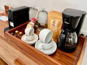 a wooden counter with cups and a coffee maker on it at The Beach Tulum Hotel in Tulum
