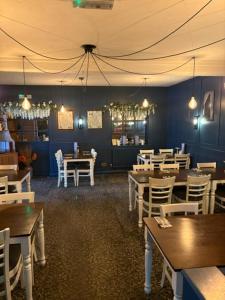 a dining room with tables and chairs and a room with blue walls at The Rag at Rawnsley in Cannock