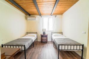 two beds in a room with a wooden ceiling at Diana 1 Apartment the Green Zone of Florence in Florence