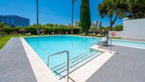 duży basen z niebieską wodą w parku w obiekcie VACATION MARBELLA I Via Celere, Huge Terrace, Brand New Complex, Close to the Beach, Marbella Center w Marbelli