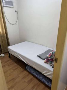 Cama pequeña en habitación pequeña con ventilador en Davao Condo 2BR Pool Wifi Netflix, en Davao City