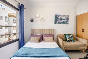 une chambre avec un lit, un canapé et une fenêtre dans l'établissement Cozy studio moderne Agdal, à Rabat