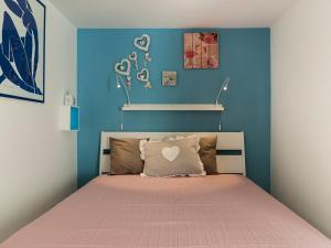een slaapkamer met een bed met een blauwe muur bij Villa Omero in Sperlonga