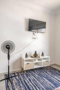 Cette chambre dispose d'une télévision et d'une table avec une lampe. dans l'établissement Cozy studio moderne Agdal, à Rabat