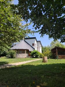 a white house with a roof in the grass at Una Serenity Villa in Bare