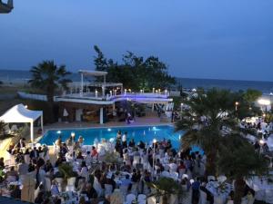 a large group of people standing around a swimming pool at Anais Hotel in Korinos