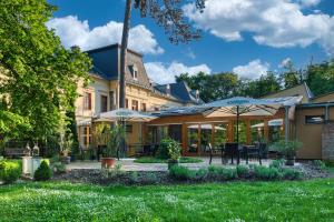 dom z dziedzińcem ze stołami i parasolami w obiekcie Főnix Wellness Resort w mieście Csitár