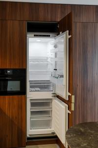 an empty refrigerator with its door open in a kitchen at Core Luxembourg -Studio Parking -50 Cents in Luxembourg