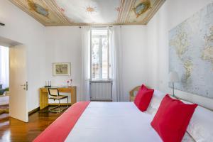 una camera da letto con un grande letto bianco con cuscini rossi di Rome Central Suite via Vittoria a Roma
