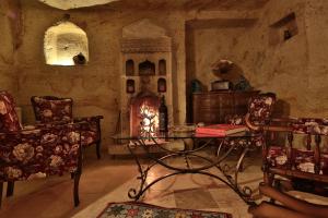 a living room with a table and chairs and a stove at Elif Stone House in Urgup