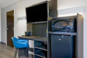a room with a microwave and a desk with a blue chair at Motel 6-Marble Falls, TX in Marble Falls