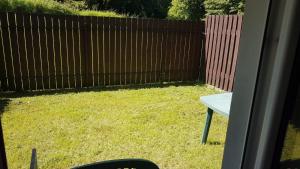 a backyard with a wooden fence and a table at Apartament Marzenie in Kowary +3 photos
