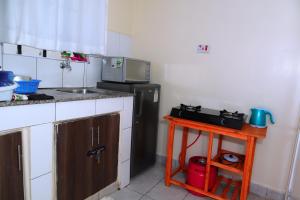 a kitchen with a black refrigerator and a table at Mareva Homes 1bedroom Thika town Ample parking wifi fridge microwave and all kitchen appliances in Thika