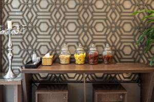 a group of jars on a table in front of a wall at Dancenter Near Hoan Kiem Lake, Old Quarter formerly Le Grand The Tryst in Hanoi