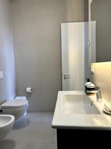 a white bathroom with a toilet and a sink at Olive Garden Villa in Himare